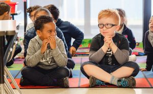 two students sitting on floor in classroom